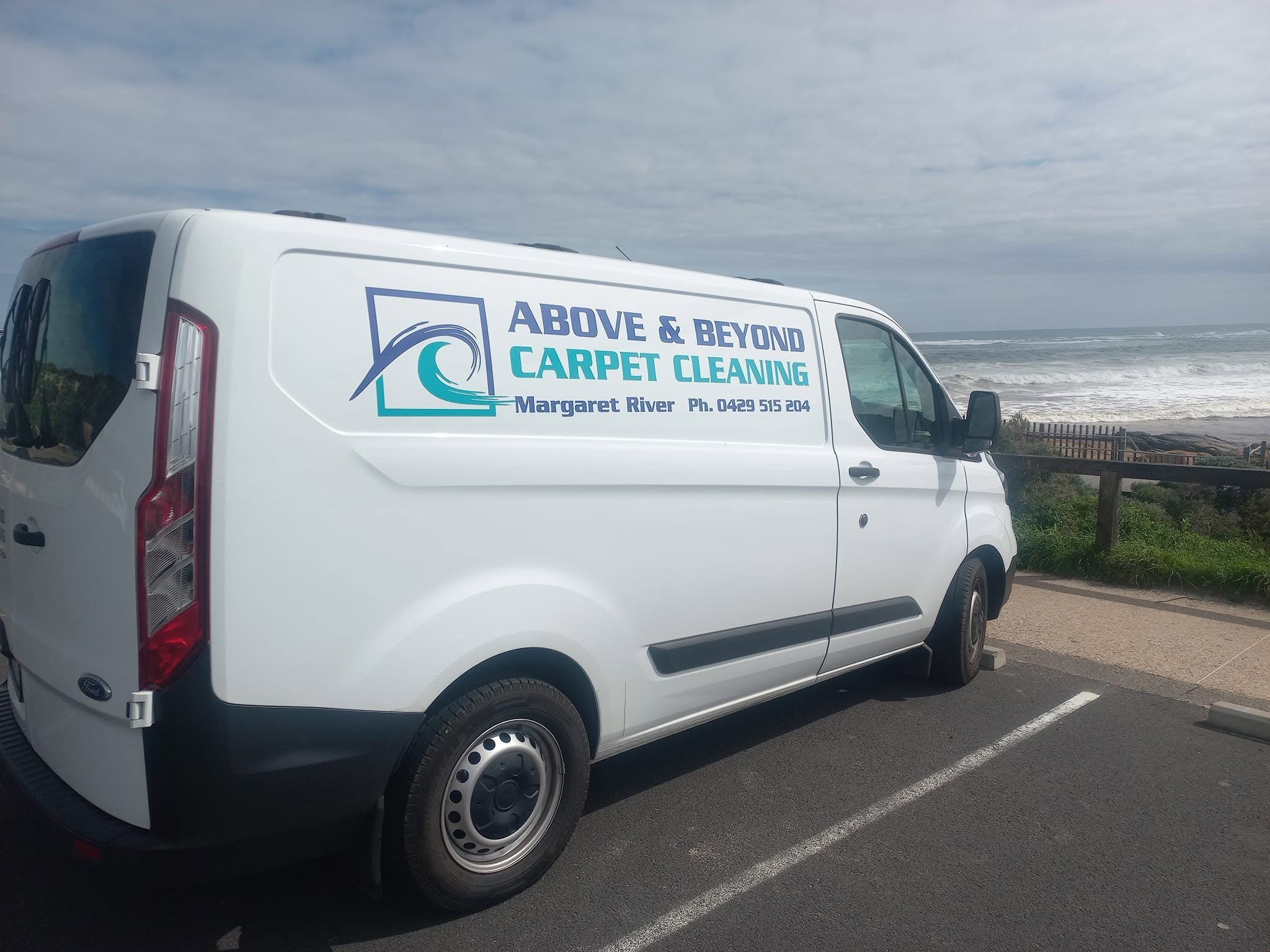 Above & Beyond Carpet Cleaning van parked beside the coast